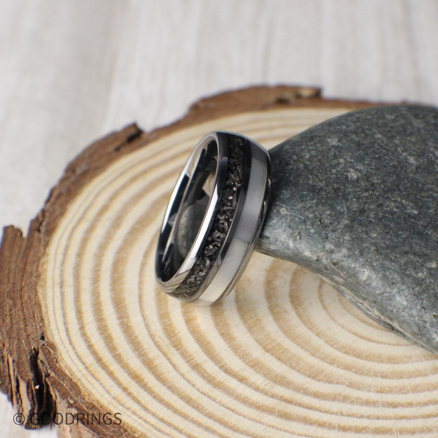 A domed tungsten men’s wedding ring crafted with meteorite and moonstone inlays, combining strength with sleek design. Packaged in a green gift box, this ring includes fast shipping, a warranty, and an exchange form for free resizing if needed.