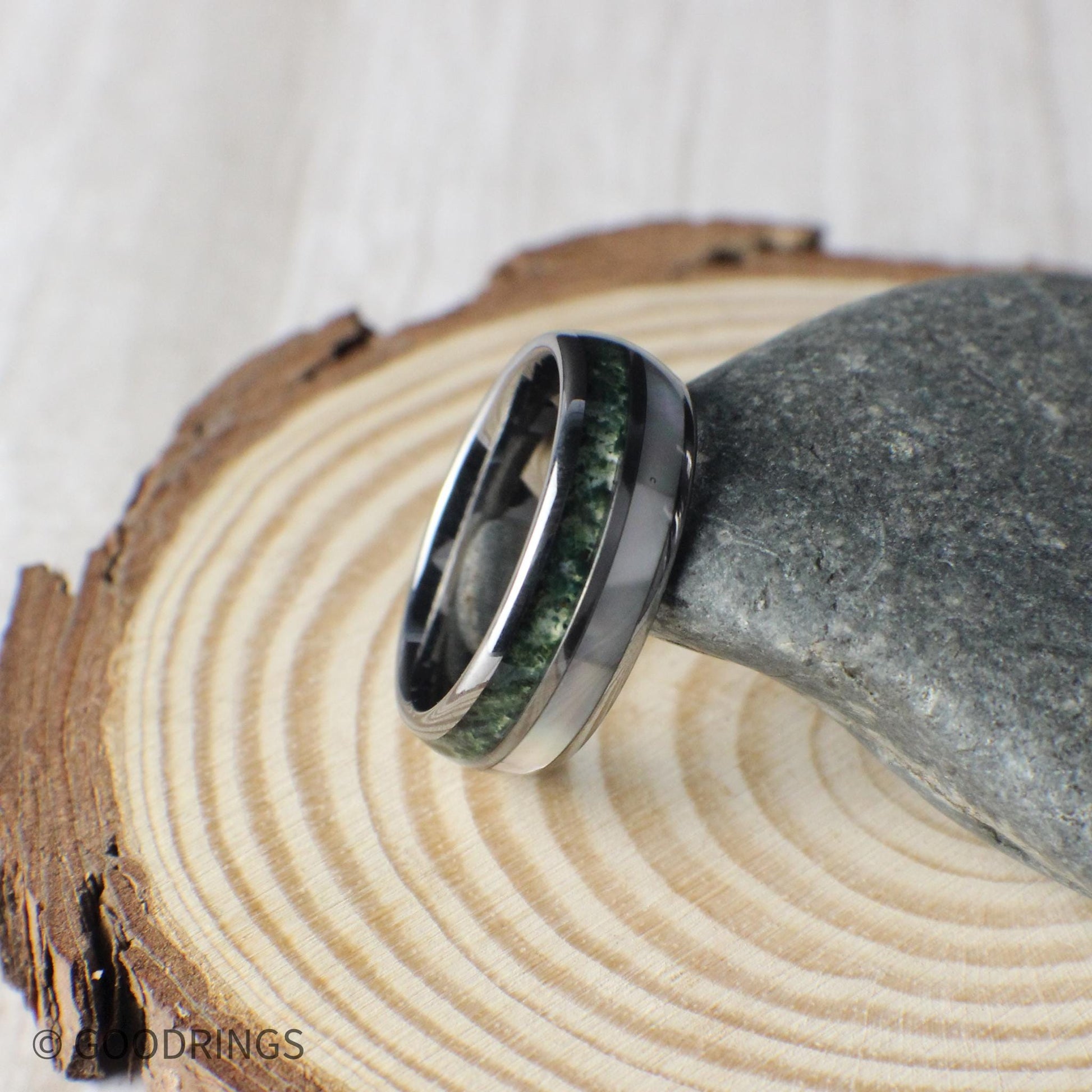 Men’s tungsten ring featuring crushed moss agate and moonstone inlays in a domed comfort-fit profile. The moss agate’s soft green tones evoke growth and nature, while the moonstone offers a luminous, polished accent. Tungsten’s superior strength ensures durability and long-lasting shine, making this band ideal for weddings, anniversaries, or meaningful everyday wear. A timeless and stylish design.