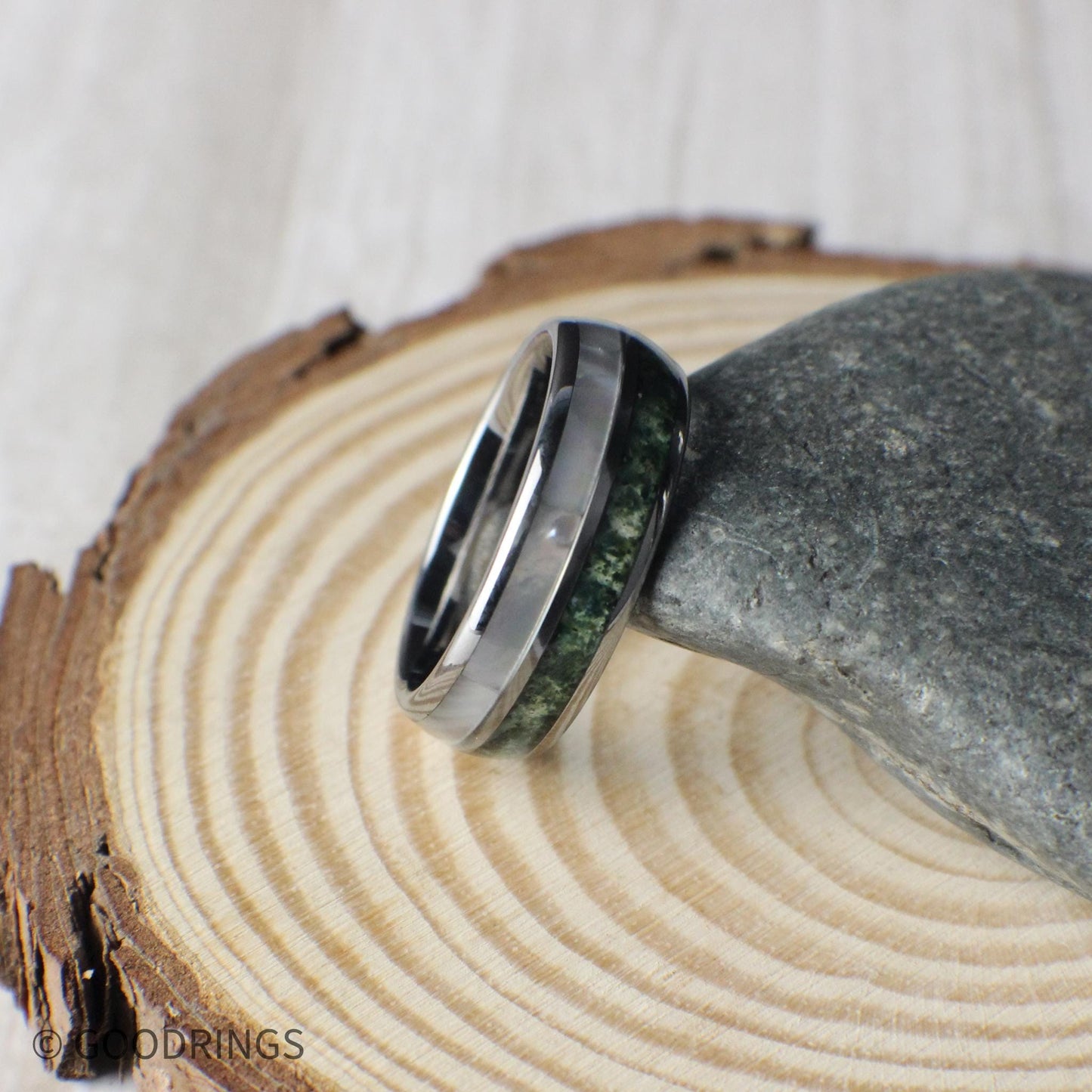 Elegant tungsten wedding band with crushed moss agate and shimmering moonstone accents. The natural green textures of moss agate create a calming, earthy feel, beautifully contrasted by the luminous moonstone. Domed for a classic shape and built with a comfort-fit interior, this scratch-resistant tungsten ring combines strength with elegance, making it perfect for weddings, anniversaries, or special occasions.