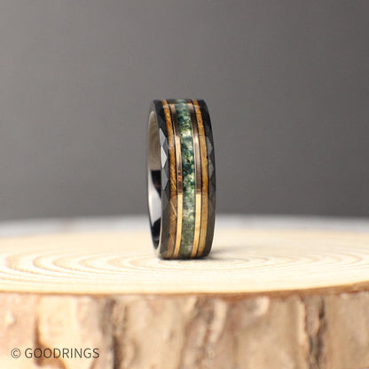 Modern and rustic 8mm hammered black tungsten ring featuring inlays of moss agate, 18K rose gold, and whiskey barrel wood. The earthy tones of agate, the warmth of rose gold, and the rich whiskey wood create a balanced design full of personality. Durable and crafted for daily wear, this comfort-fit ring is a striking choice for a wedding band, anniversary gift, or a personal keepsake that stands out.