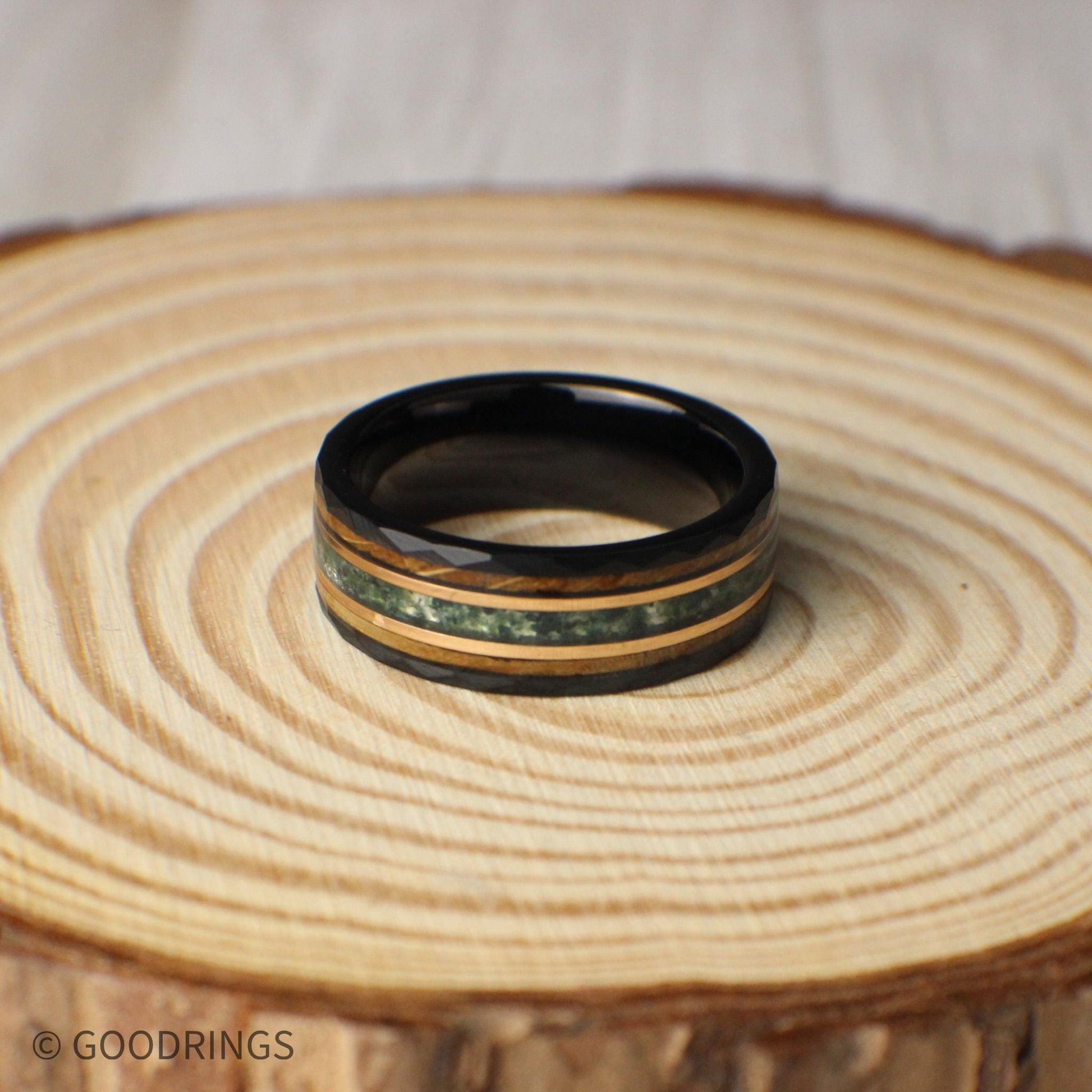 Unique hammered tungsten ring in black, measuring 8mm wide with an eye-catching inlay combination of moss agate, 18K rose gold, and whiskey barrel wood. Each element adds depth and meaning—the moss agate symbolizes growth, the rose gold conveys warmth, and the whiskey barrel wood reflects history and tradition. Strong, stylish, and meaningful, this ring makes a statement for weddings or special milestones.
