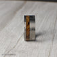 Masculine 10mm tungsten ring styled after the chamber of a revolver, featuring recessed grooves for a unique, rugged finish. A striking inlay of charred whiskey barrel wood runs through the band, symbolizing tradition and heritage while adding natural character. Perfect for weddings, anniversaries, or as a bold statement piece, this durable comfort-fit band combines grit, style, and individuality.