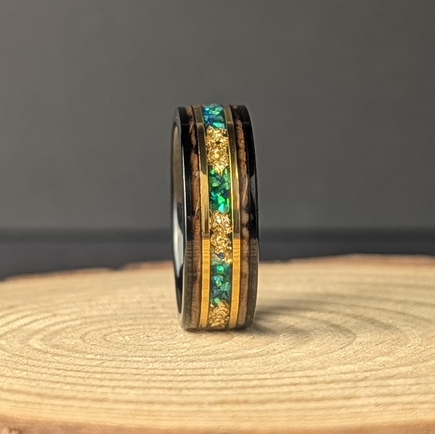 Men’s 8mm tungsten wedding band with green opal inlay, whiskey barrel wood interior, and thin 18K gold accents