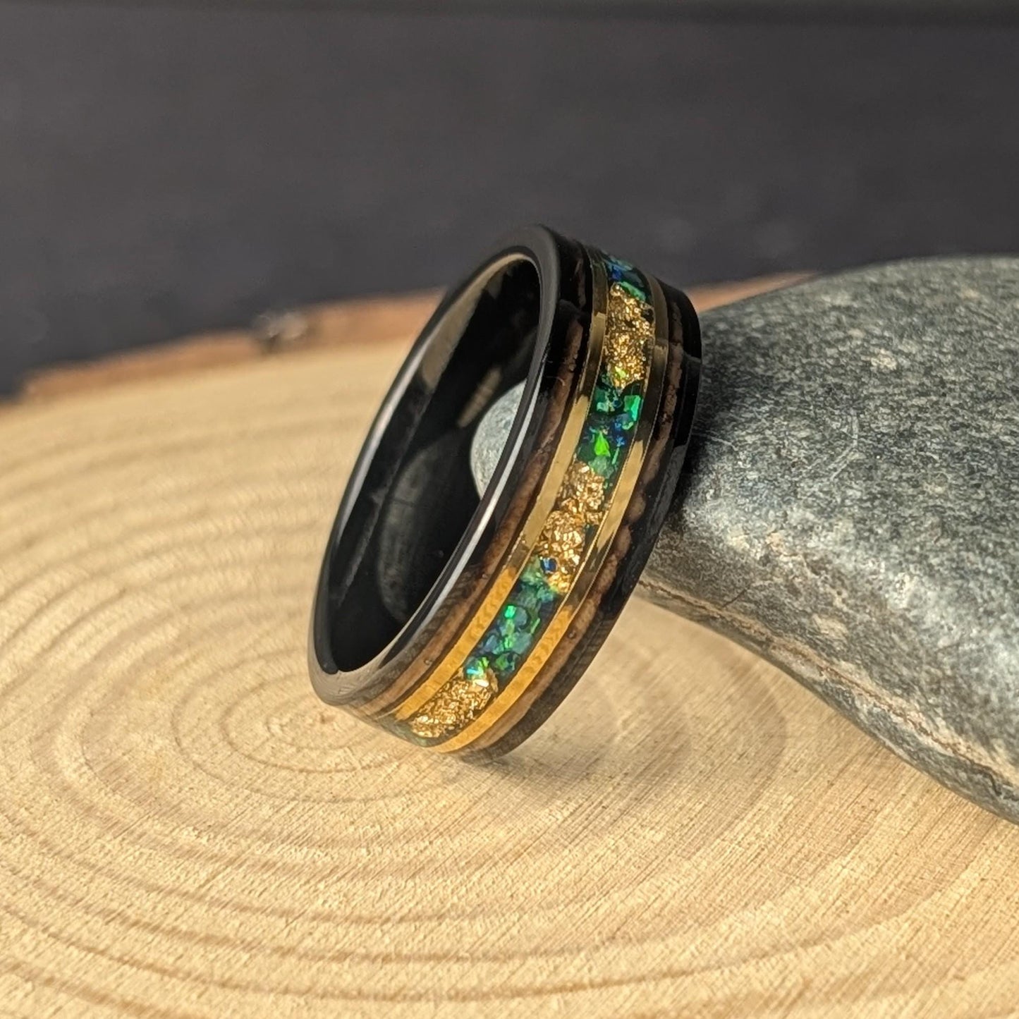Rustic men’s wedding ring with green opal inlay, whiskey barrel wood interior, and polished tungsten exterior