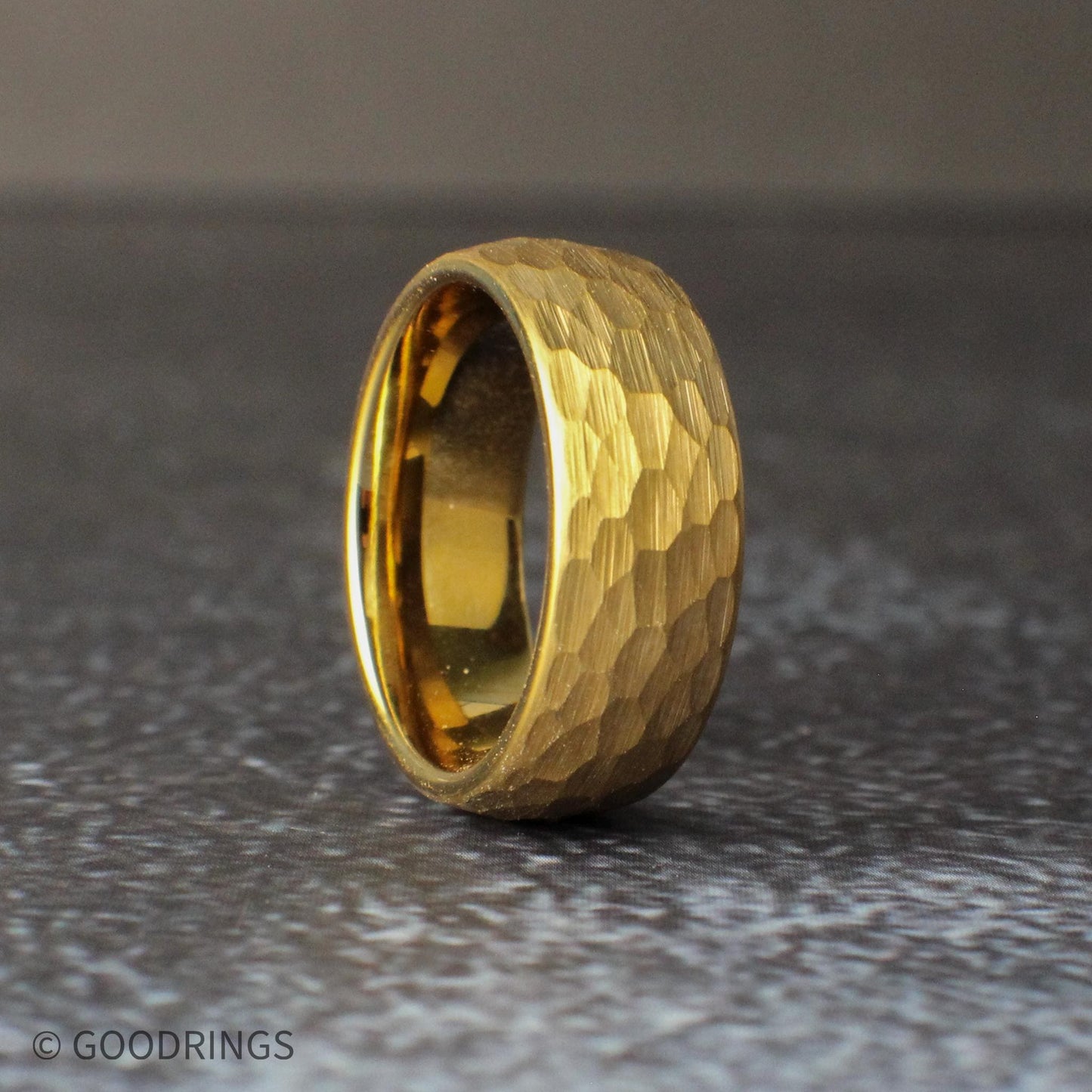 Stack of hammered gold tungsten rings in different widths demonstrating size options from thin 2mm to bold 8mm bands. Each ring features a domed shape and textured hammered finish, creating a dynamic gold surface. These rings are perfect for matching wedding bands, couple sets, or minimalist gold jewelry with added character.