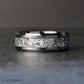 Silver wedding band laying down flat