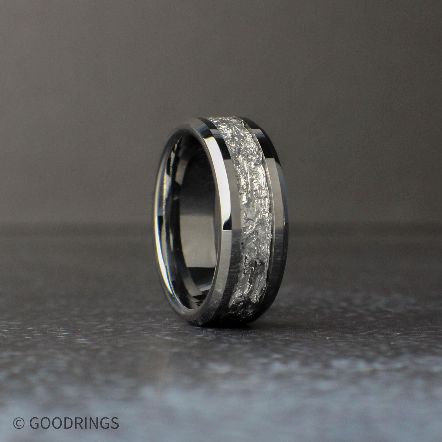 Silver wedding band standing vertically