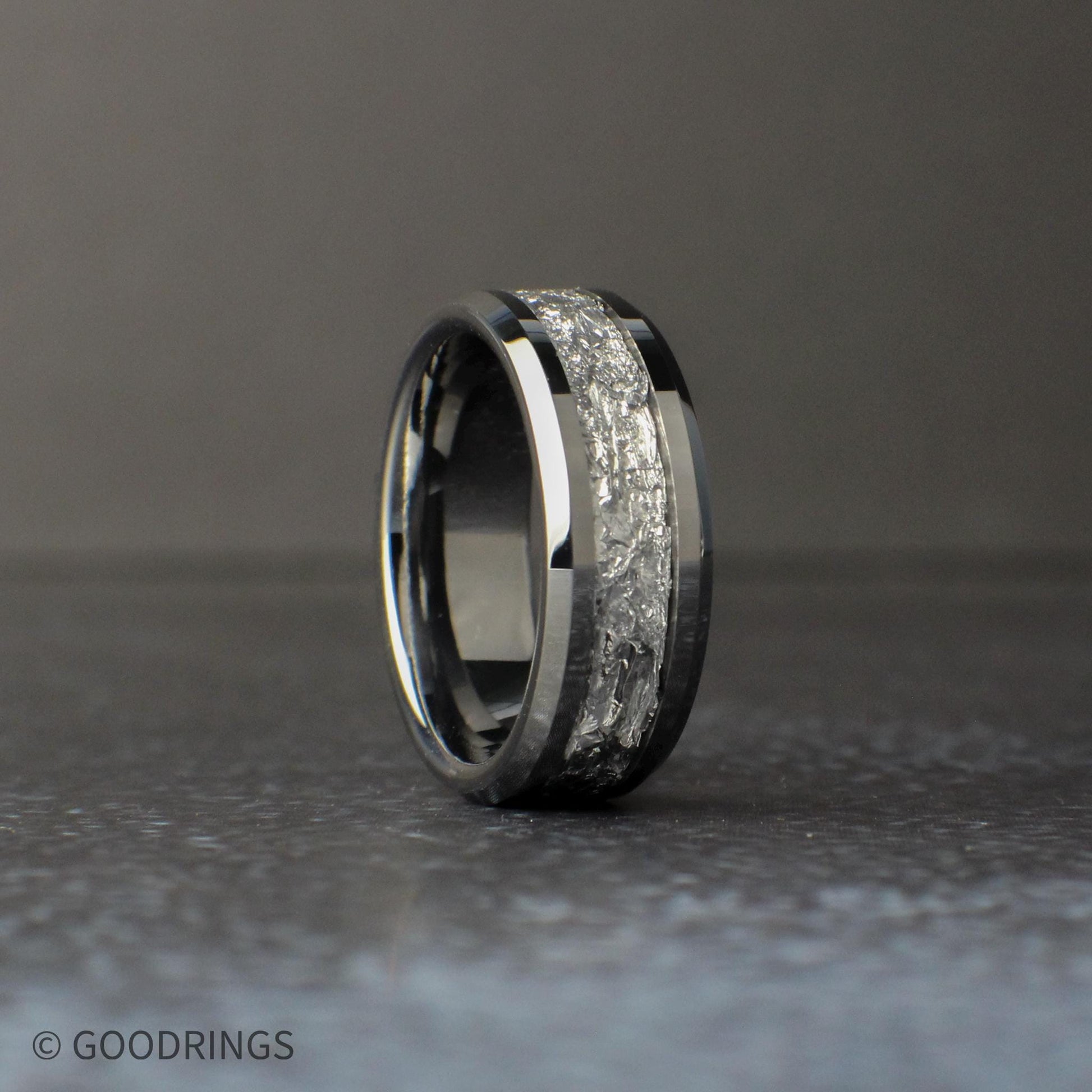 Silver wedding band standing vertically