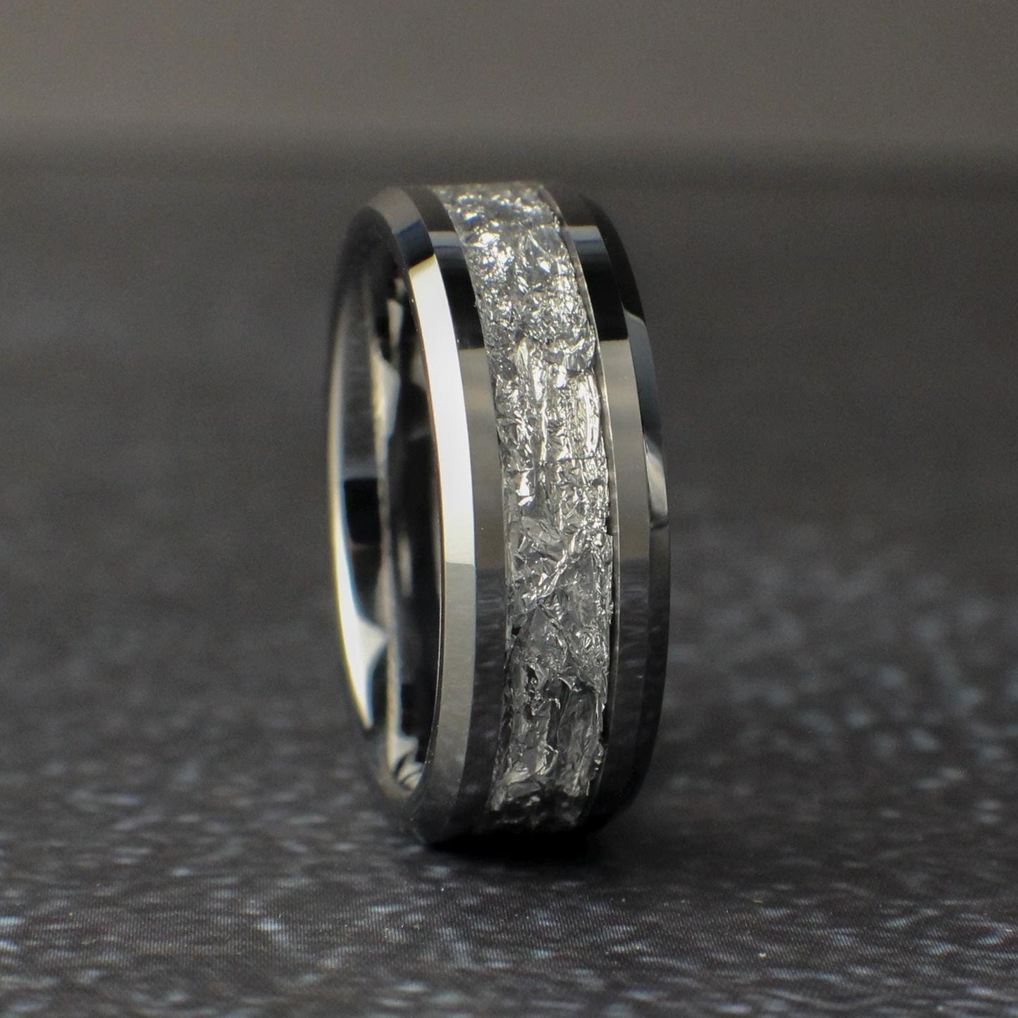 Mens Silver Wedding Ring standing vertical on a black background