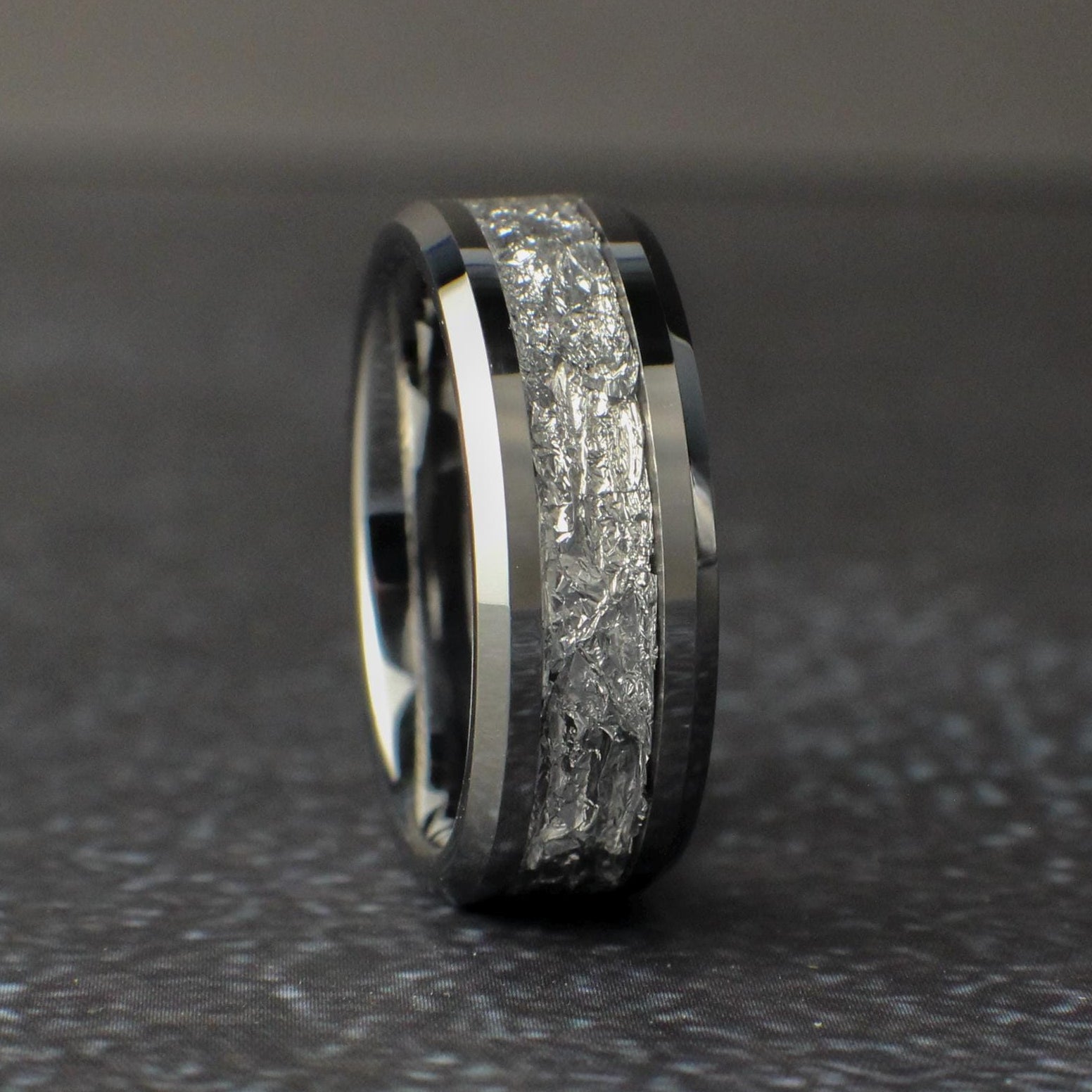 Mens Silver Wedding Ring standing vertical on a black background
