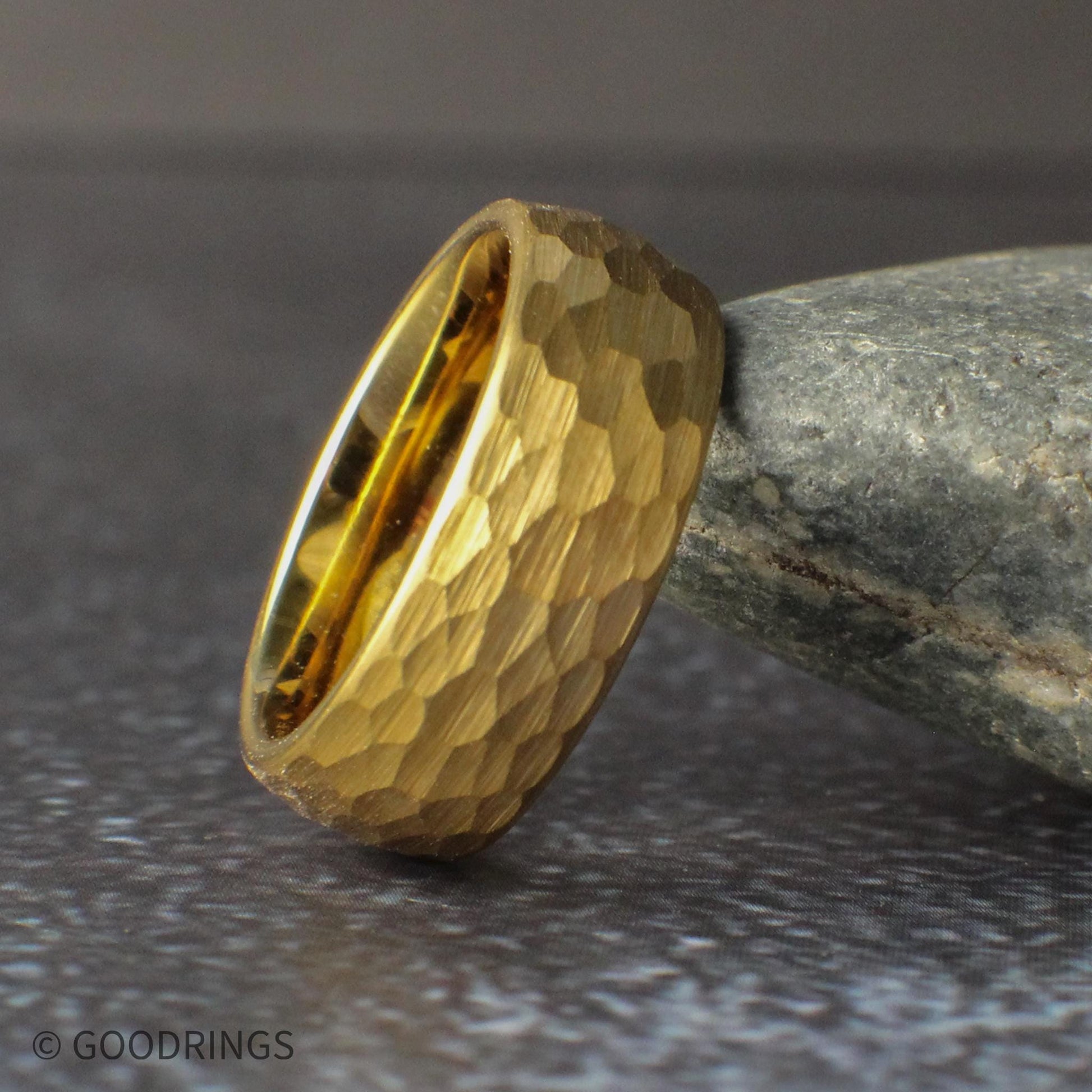 Multiple gold tungsten rings arranged together to showcase the hammered texture and domed profile. Available in 8mm, 6mm, 4mm, and 2mm widths, these rings offer a versatile option for couples wanting matching wedding bands or individuals seeking a durable and stylish gold ring.