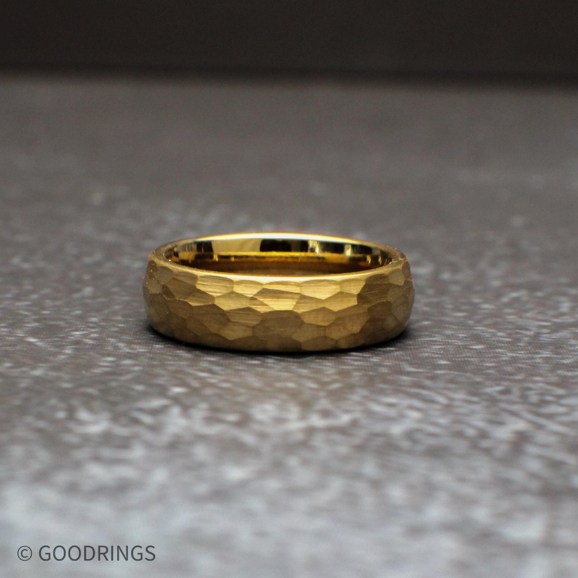 Side angle view of hammered gold tungsten rings showing the domed profile and comfort fit interior. The 18K gold plated finish pairs with the textured surface to create a durable and stylish wedding band suitable for daily wear and long-lasting performance.