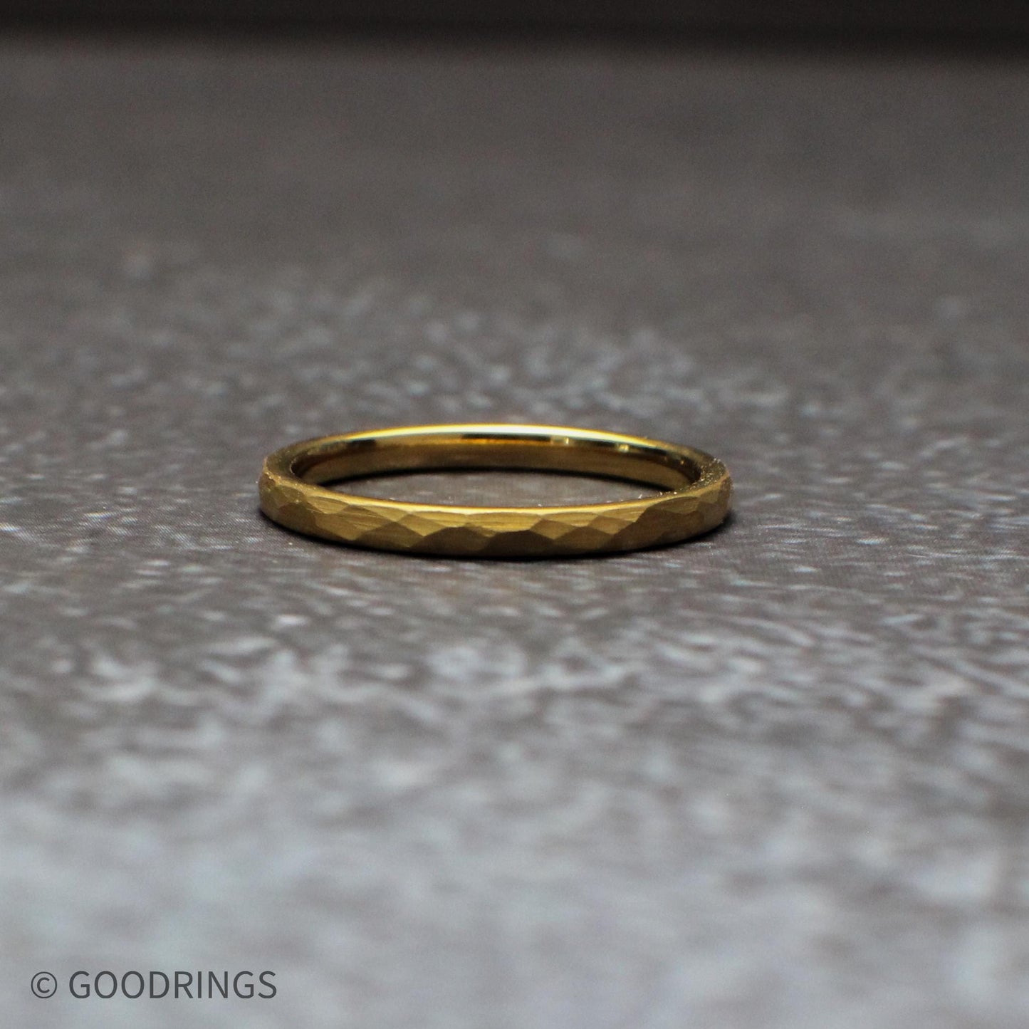 Close-up detail of the hammered texture on a gold tungsten ring, highlighting the faceted surface that catches light from every angle. This 18K gold plated band combines durability with visual depth, making it a standout choice for wedding bands and everyday rings.