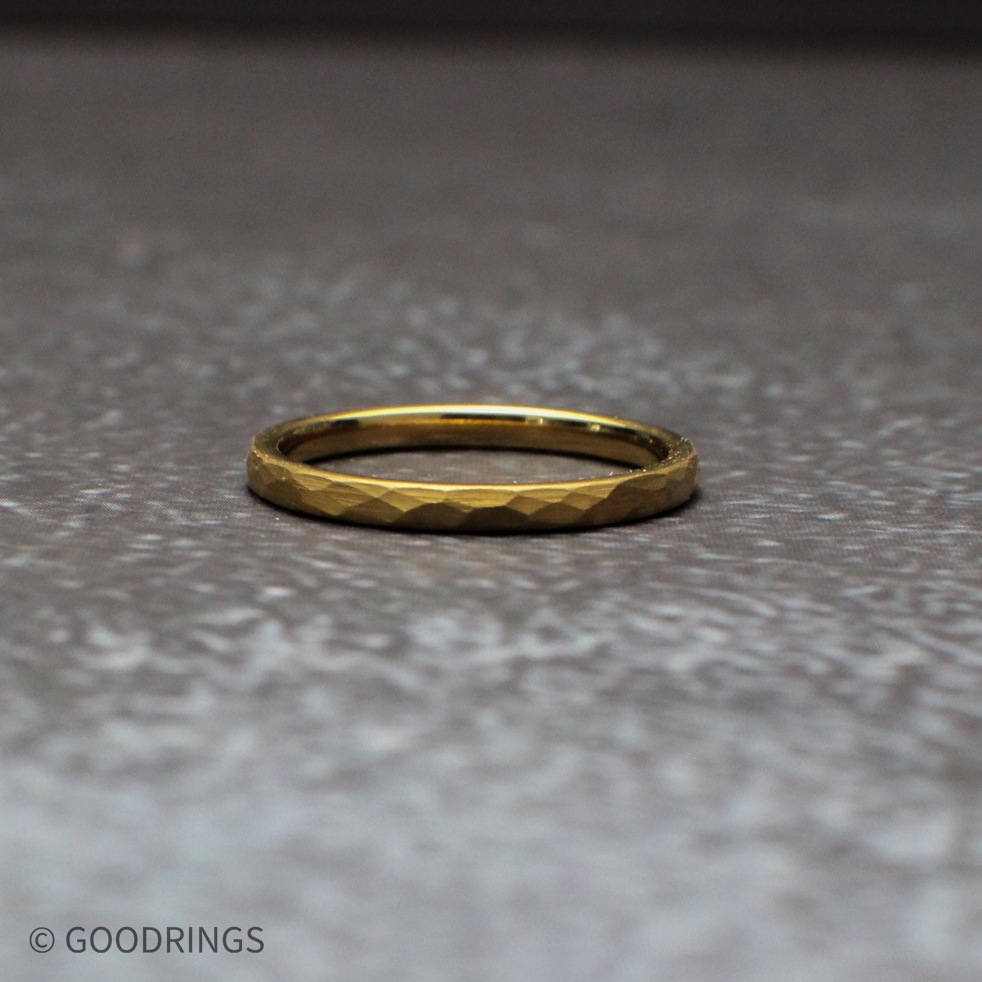 Close-up detail of the hammered texture on a gold tungsten ring, highlighting the faceted surface that catches light from every angle. This 18K gold plated band combines durability with visual depth, making it a standout choice for wedding bands and everyday rings.
