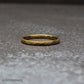 Close-up detail of the hammered texture on a gold tungsten ring, highlighting the faceted surface that catches light from every angle. This 18K gold plated band combines durability with visual depth, making it a standout choice for wedding bands and everyday rings.