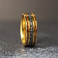 Mens wedding band standing straight up on textured tile
