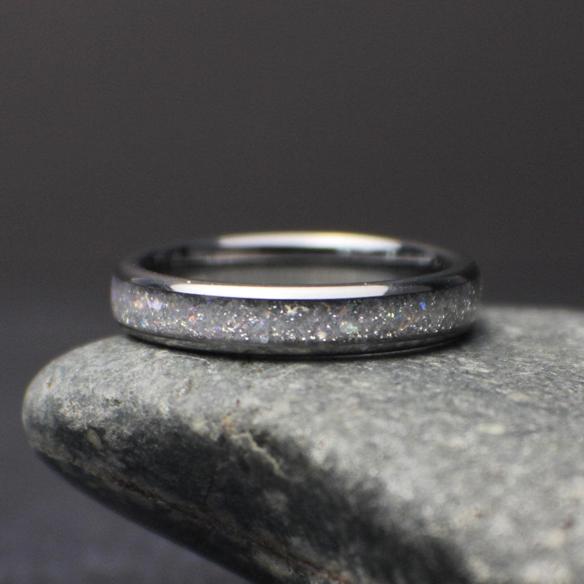 top view of minimalist 4mm moonstone band resting on stone highlighting subtle shimmer and comfort fit design