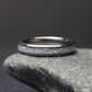 top view of minimalist 4mm moonstone band resting on stone highlighting subtle shimmer and comfort fit design
