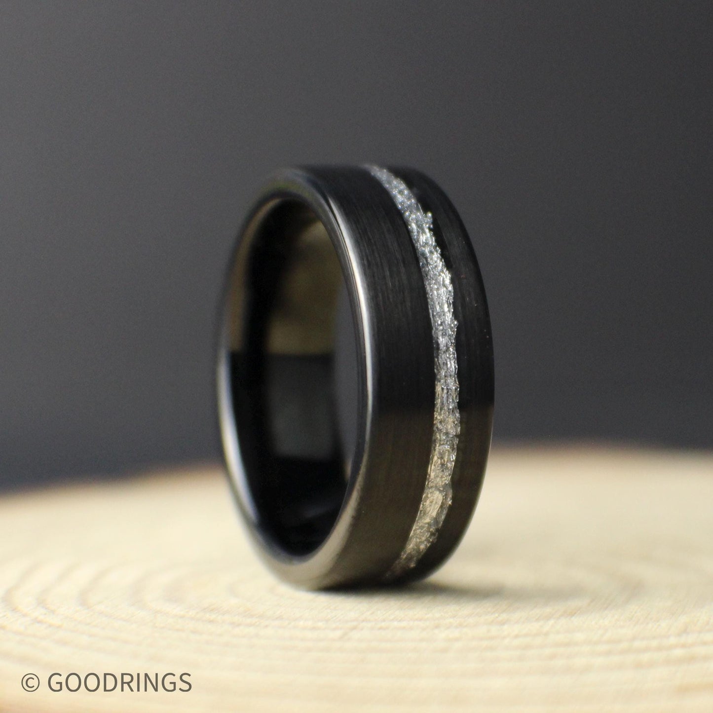 Front view of an 8mm black tungsten men’s wedding band with a narrow genuine silver leaf inlay and brushed finish.