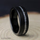Angled close-up of an 8mm black tungsten men’s ring showing its brushed finish, comfort fit interior, and silver leaf inlay.