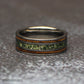 Low front view of the tungsten ring lying on its side, highlighting the mottled green moss agate center and parallel brown wood inlays.