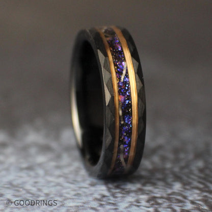 Low angled view of the black tungsten ring lying on its side, displaying the galaxy-inspired center inlay and faceted geometric edges.