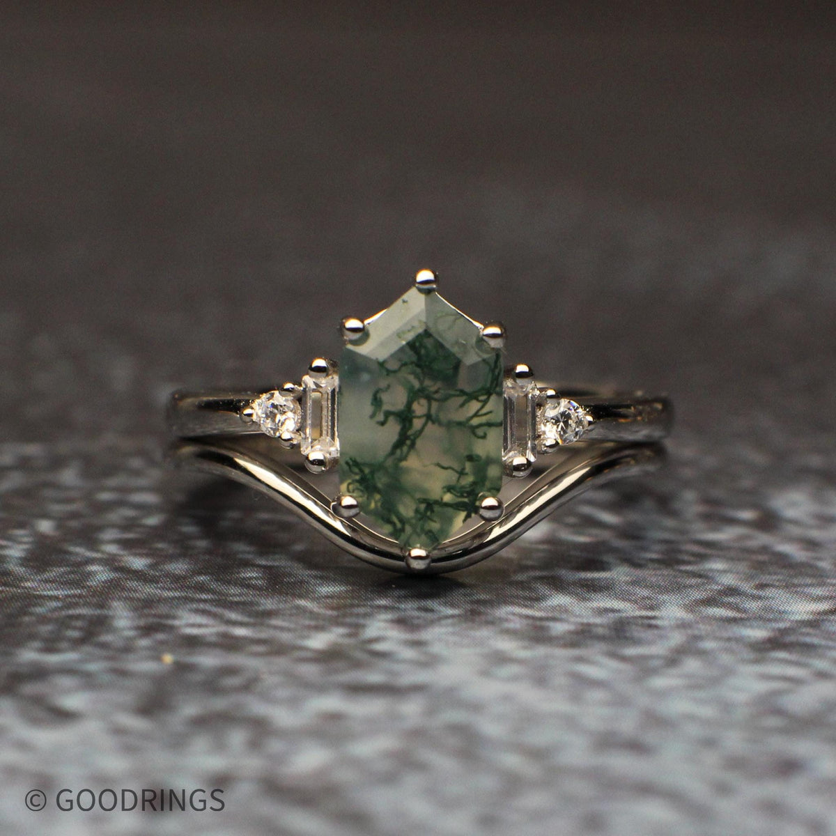 Close front view of the moss agate engagement ring and curved silver band, highlighting the stone’s translucent green branching pattern.