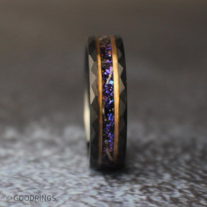 Angled view of the black tungsten ring standing upright, highlighting the colorful galaxy inlay, meteorite fragments, and geometric faceted edges.