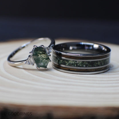 Coordinated moss agate couples rings resting on a light wood surface, showing the patterned center stone and crushed green inlay side by side.