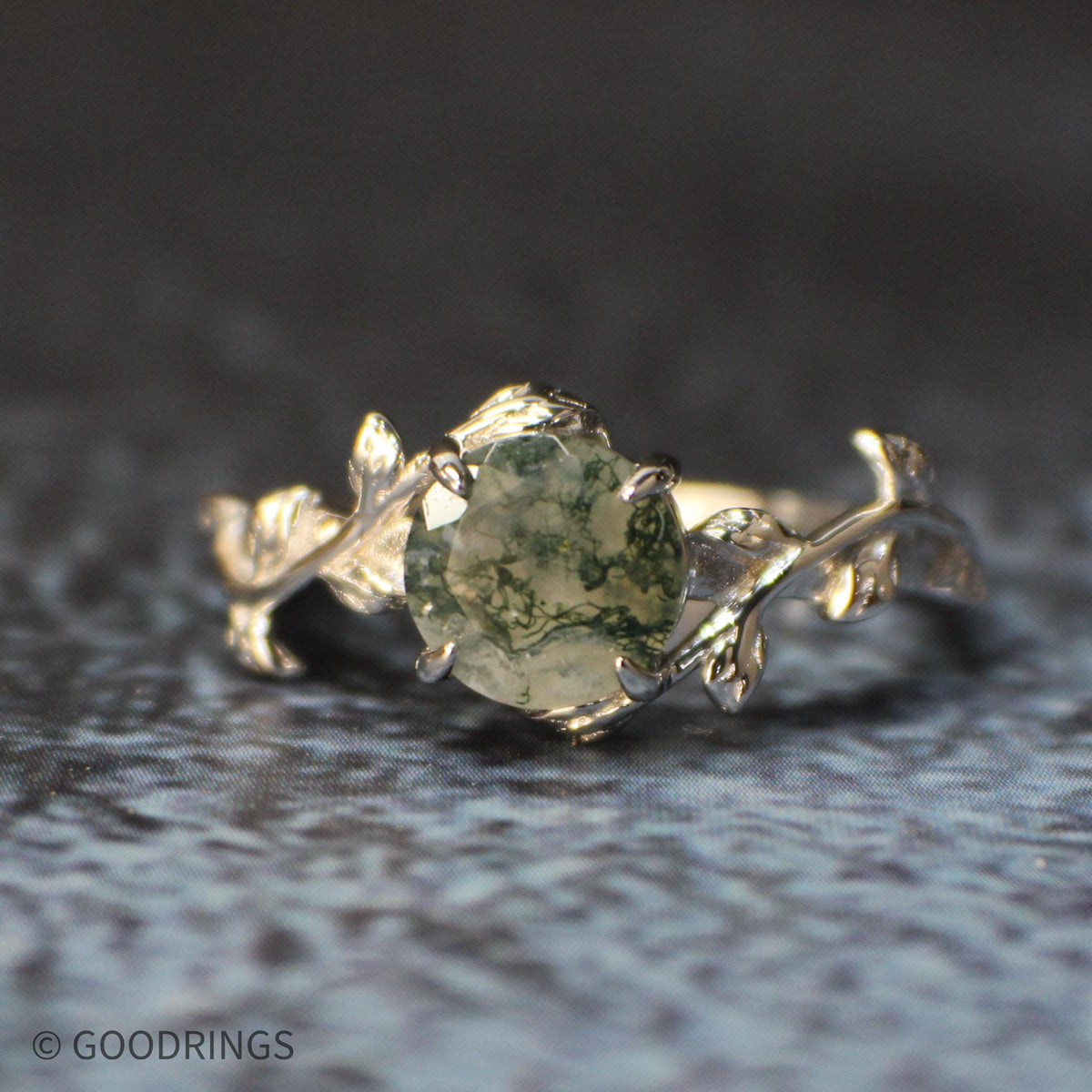close up view of moss agate engagement ring with silver leaf's