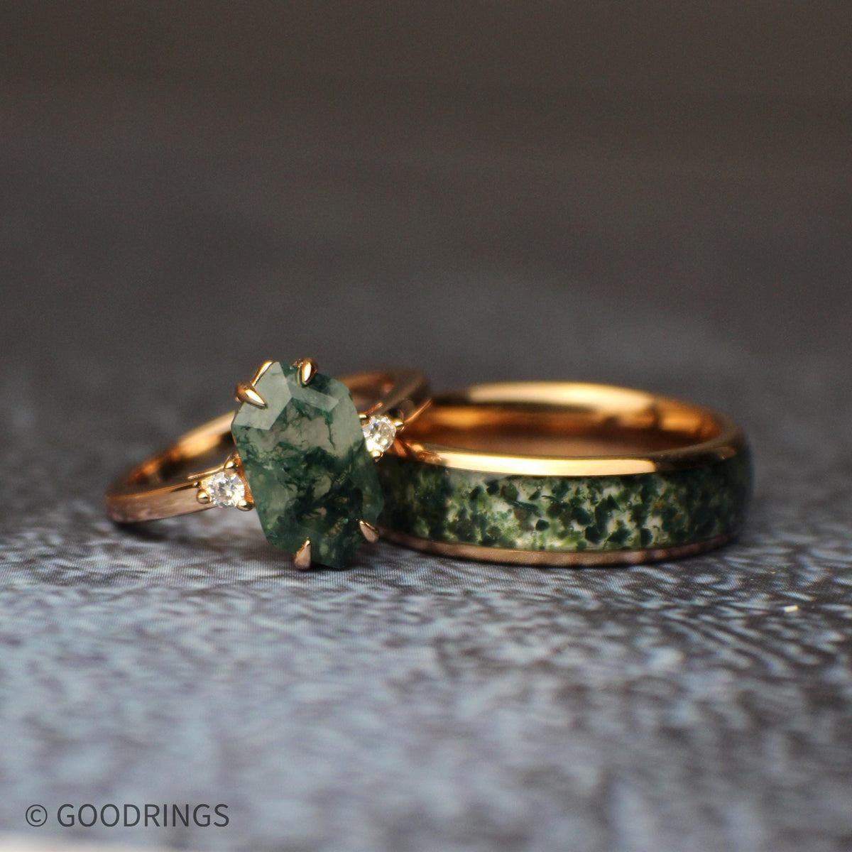Couples set of moss agate wedding rings laying on each other