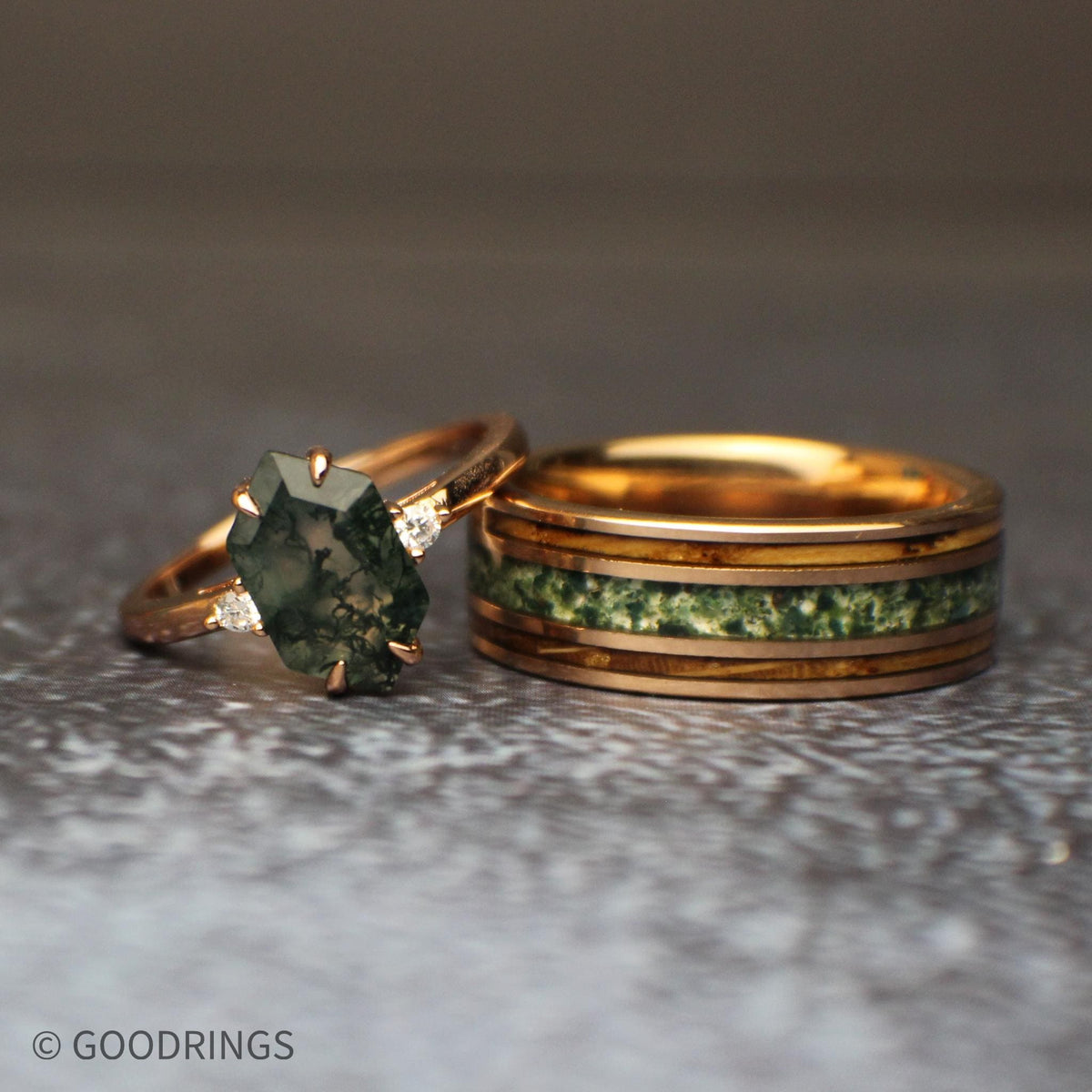 Great looking female moss agate ring leaning on an 8mm wide mens ring