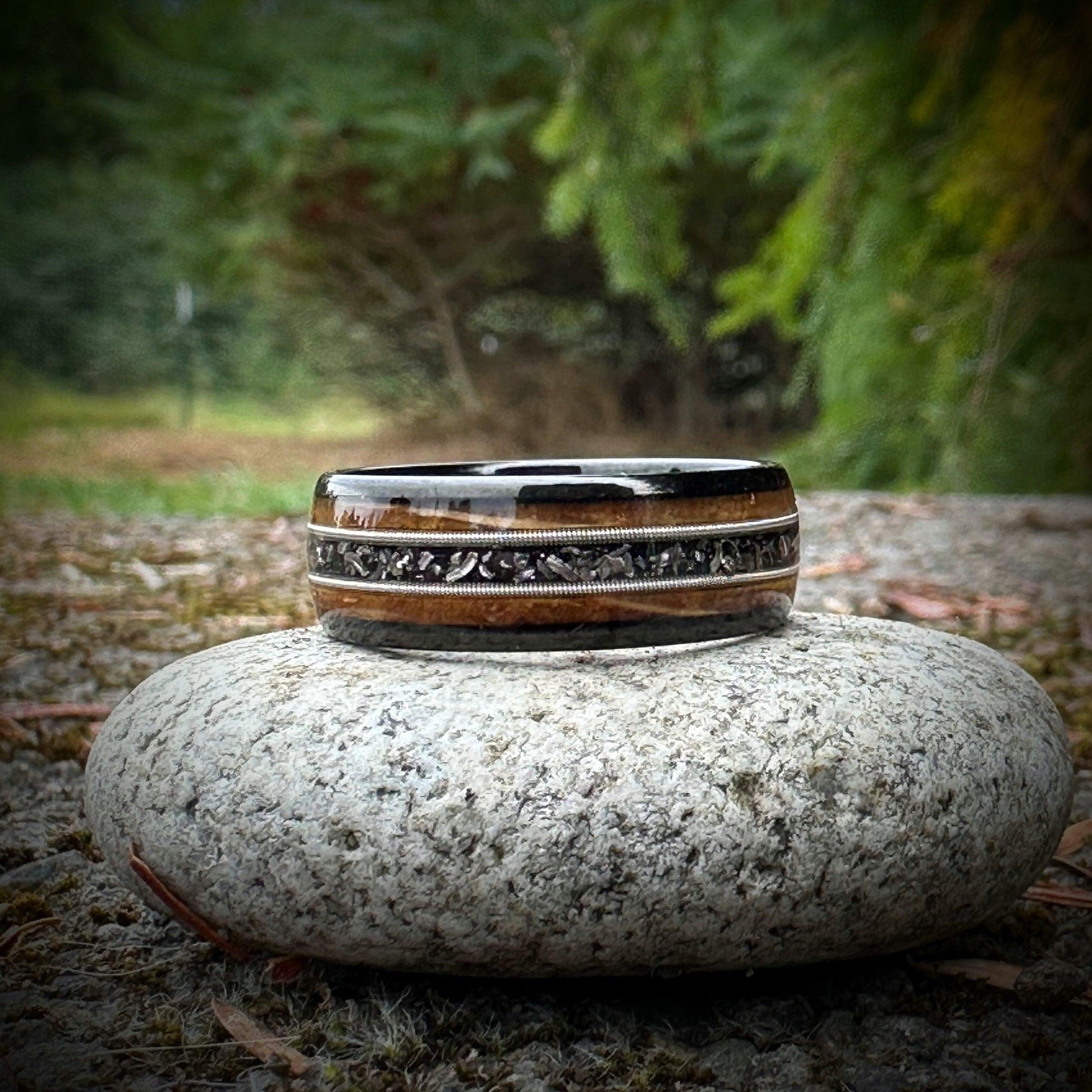 Wedding band made out of whiskey barrel, guitar string, and meteorite.